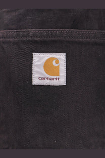 Black Carhartt WIP men’s Everson Bradford cotton trousers with a white label featuring an orange logo and brand name
