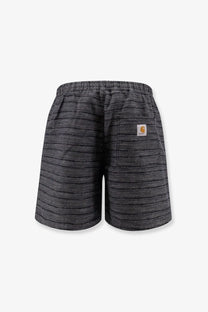 Back view of black and gray striped carhartt wip men’s gellar relaxed fit shorts with woven texture and orange logo patch
