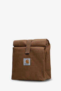 Brown canvas Carhartt Wip men’s roll-top lunch bag with white patch and orange logo for durable everyday use