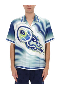 Blue and white short-sleeved button-up shirt with swirling flame-like graphic on front from Casablanca men’s collection