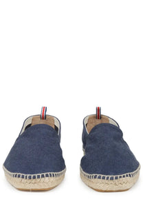 Navy blue canvas espadrille slip-on shoes with woven jute sole and red white and blue striped pull tab back view
