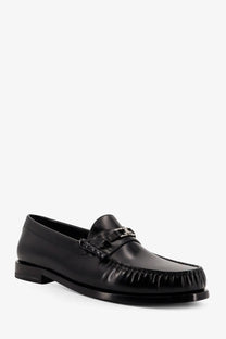 Black leather moccasin loafer with silver metal buckle and frayed toe detailing by Celine for men