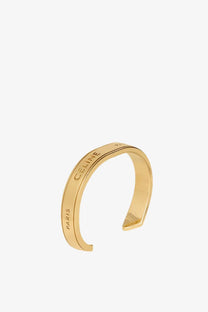 Gold-tone celine paris open cuff brass bracelet with sleek minimalist design for women