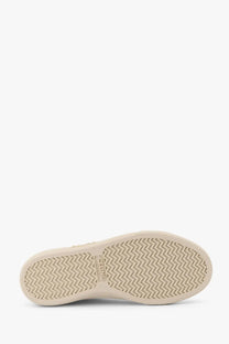 Back view of celine women’s white triomphe canvas sneakers showing beige rubber sole with zigzag tread and celine logo