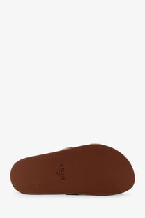 Brown leather celine slide sandal with minimalist design and embossed branding on the sole in beige color