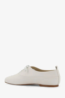 Celine women’s Triomphe Richelieu leather lace up shoe in cream color with low profile sole and white laces