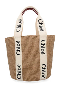 Beige woven straw tote bag with cream handles black chloé lettering and dark brown leather accents from Chloé Woody Large White