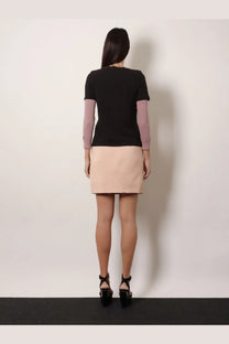 A woman wearing a chloé women’s black cotton shirt paired with a lavender and beige color-blocked skirt