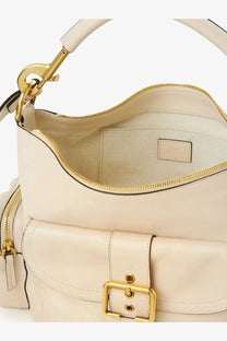 Cream-colored leather hobo bag with gold-tone hardware and a front buckle closure.