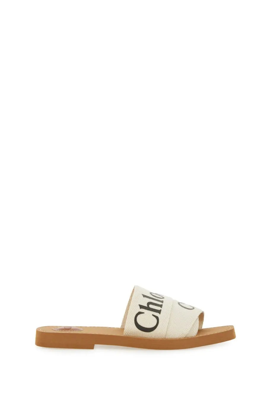 Chloé women’s white canvas slide sandal with black branding on strap and tan rubber sole in Woody style