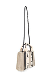 Beige canvas chloé women’s tote bag with black leather straps and bold branding on the sides