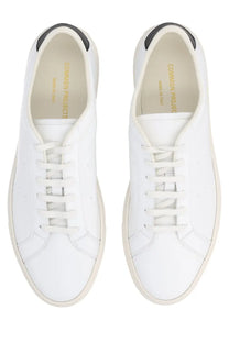 Common projects men’s sneaker achilles white leather with black heel tabs and cream soles minimalist design back view