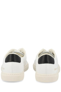 Common Projects men’s sneaker Achilles white with white leather, black rubber heel tabs, beige soles, minimalist design back view