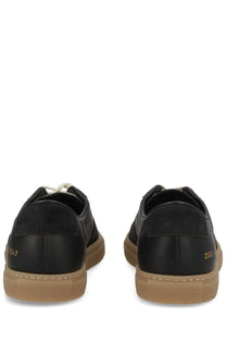 Common projects men’s sneaker bball black showing back with black leather, tan rubber soles, and gold branding on heel