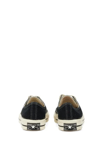 Black canvas converse unisex chuck vintage low-top sneakers with white rubber soles and star logo on the heel back side