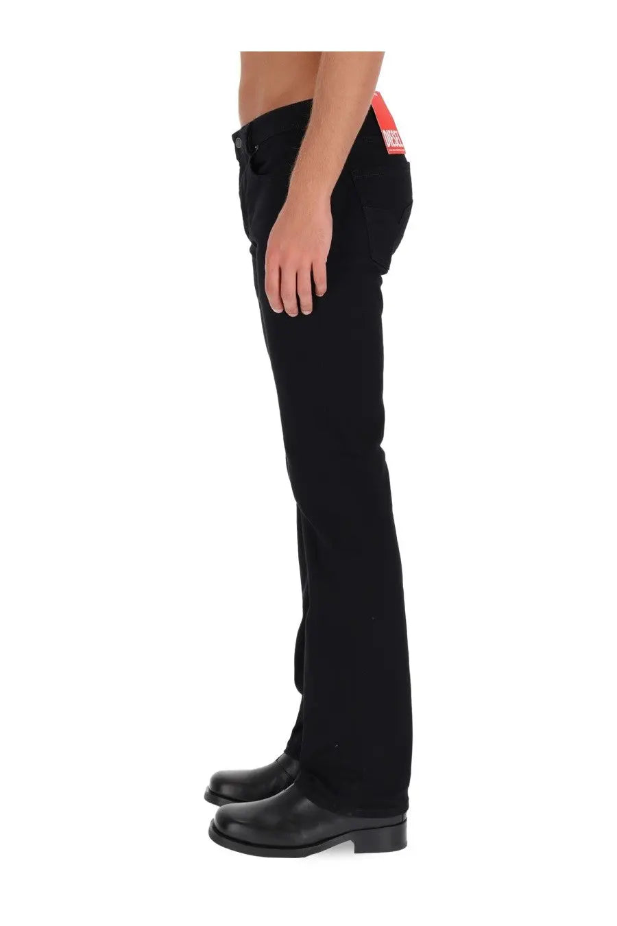 Diesel men’s black denim jeans with red brand tag at the waistband showing the back side of the product