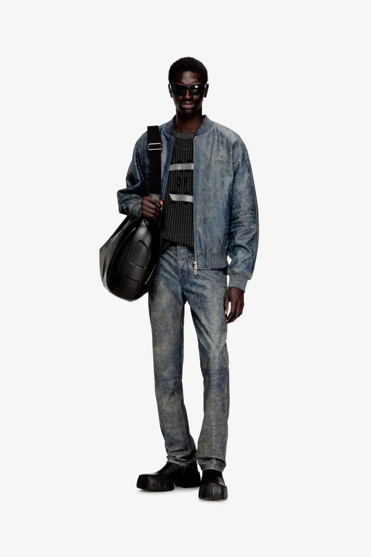 Black leather shoulder bag with structured minimalist design and visible stitching details paired with diesel mens vyll qmbw leather trousers blue
