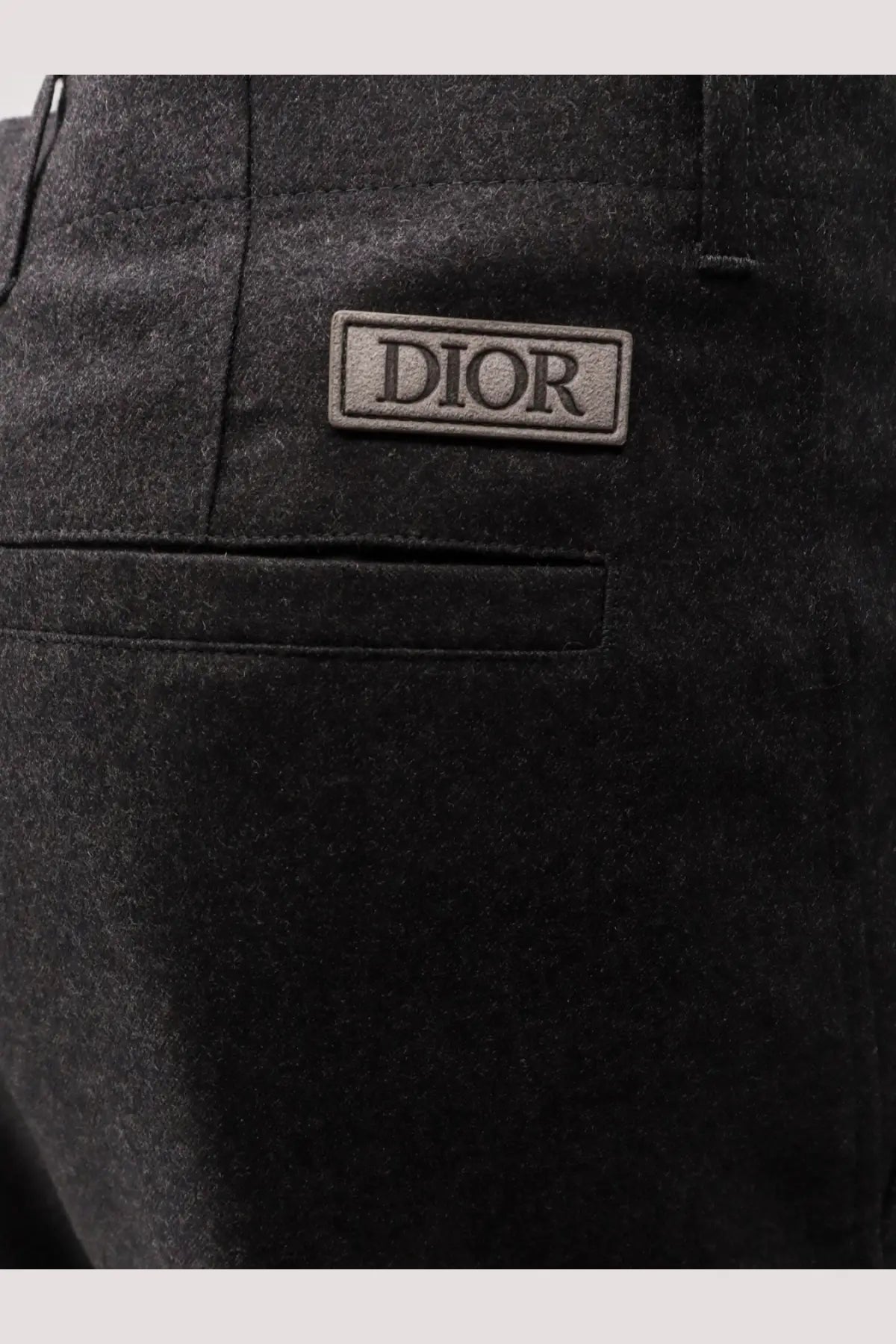Back view of black dior men’s wool trousers with a rectangular brand patch on the back pocket