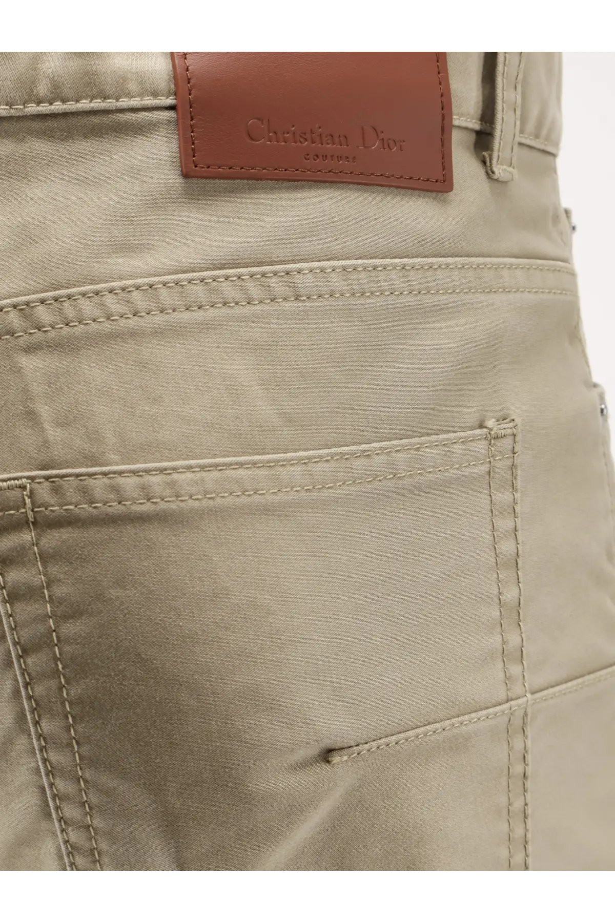 Beige christian dior men’s cotton trousers with brown leather brand patch and neatly stitched seams on the back side