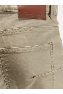 Beige christian dior men’s cotton trousers with brown leather brand patch and neatly stitched seams on the back side