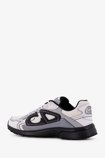 Dior men’s gray nylon sneakers with white and gray athletic design and black accents featuring a bold abstract logo