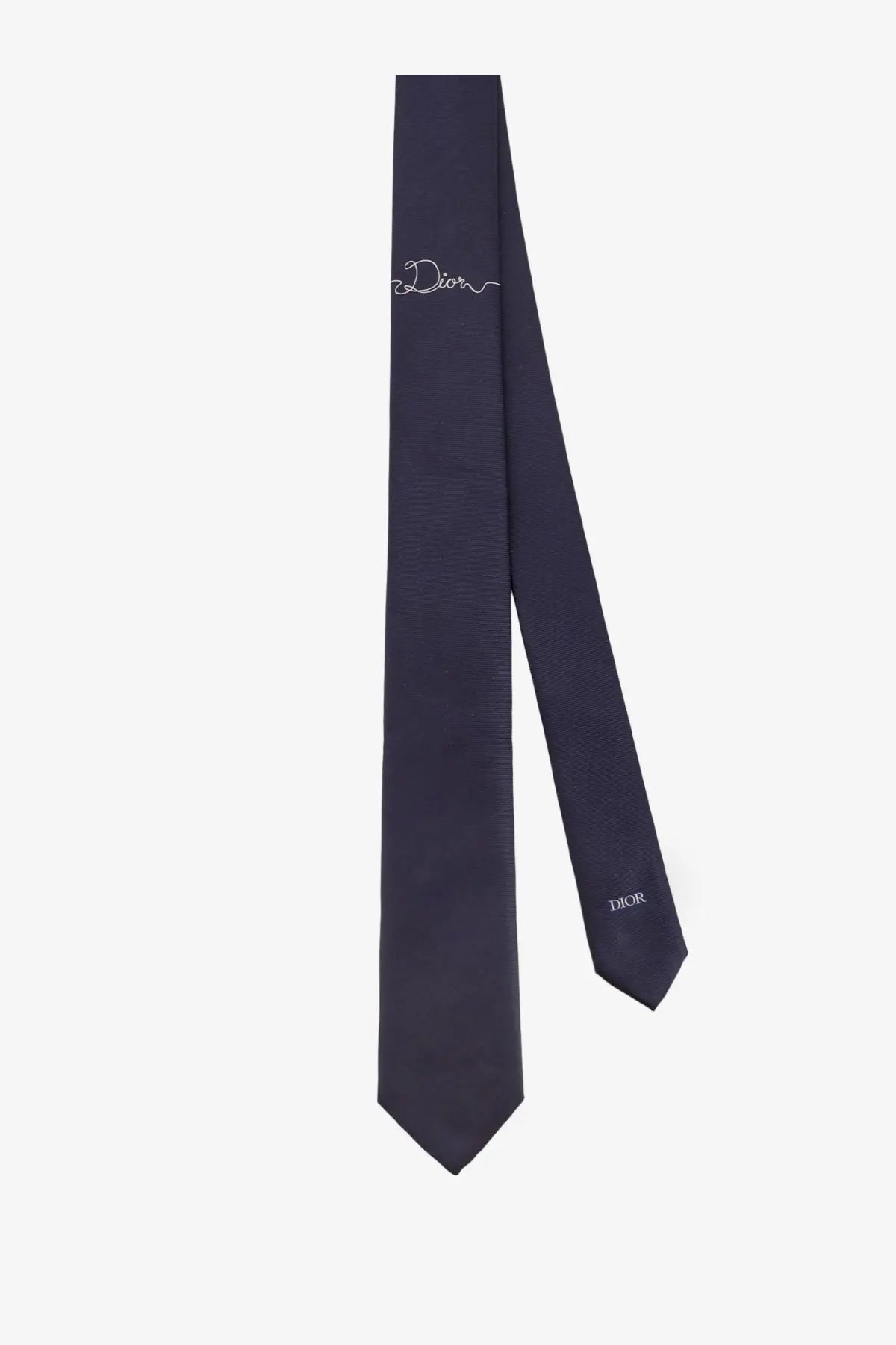 Navy blue Dior men’s silk tie featuring a subtle white embroidered logo and printed brand name at the tip