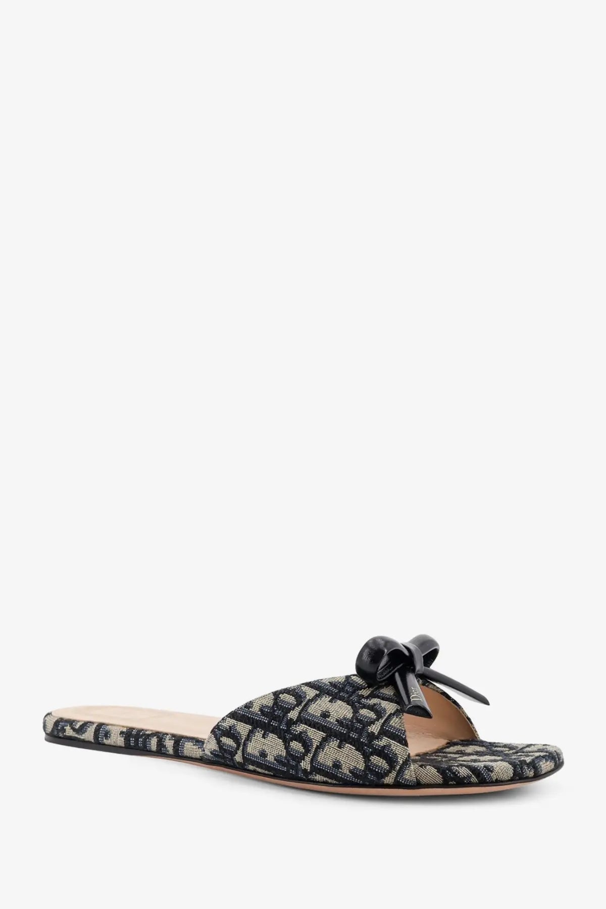 Dior women’s beige slide sandal with black leather bow and black and beige Dior oblique fabric pattern