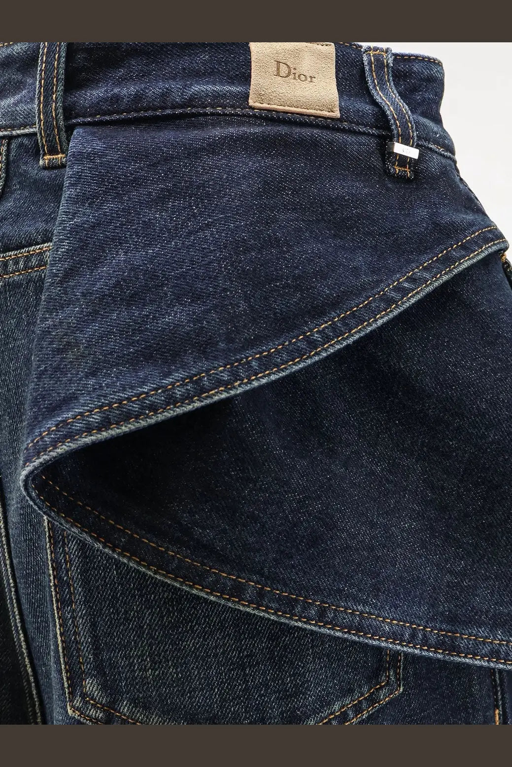 Dark blue denim Dior women’s draped flared jeans with contrasting stitching and a Dior brand label visible