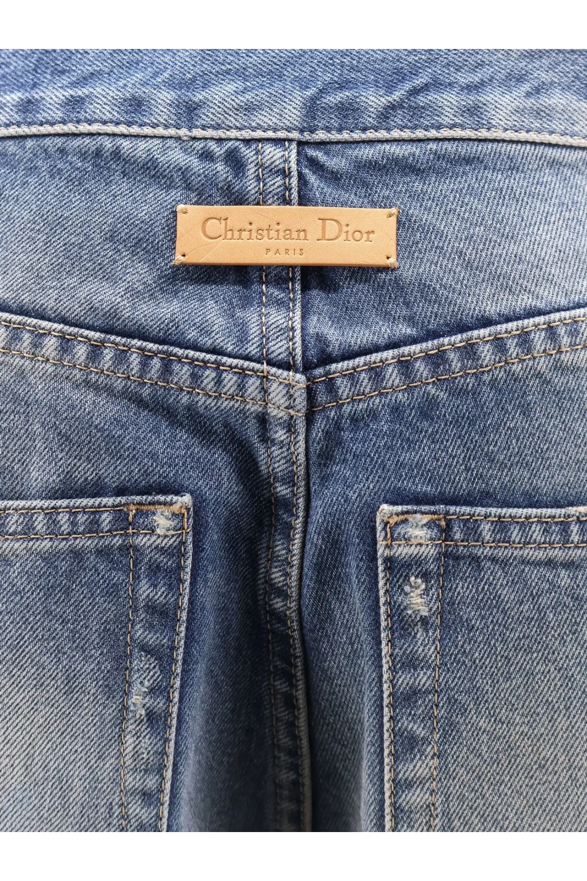 Blue denim dior womens flared jeans showing tan leather christian dior paris label at the waistband back side