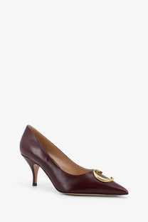 Burgundy leather pump with gold-tone circular buckle at the toe from dior women’s dior initials leather pumps black collection
