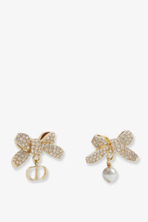 Dior women’s metal earrings gold featuring gold-tone bows with sparkling crystals and dangling Dior logo charm or pearl