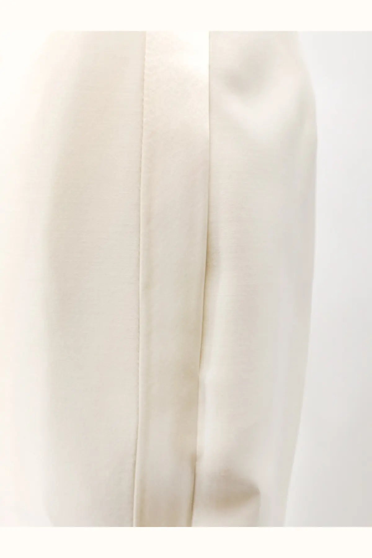 Cream-colored satin skirt with smooth flowing drape and subtle vertical seams complementing Dior wool silk trousers white