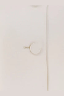 White circular button with metallic textured shank on light fabric of Dior women’s wool and silk blend jacket white