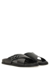 Dolce &amp; Gabbana men’s black calfskin leather slide sandals with a prominent metallic DG logo buckle