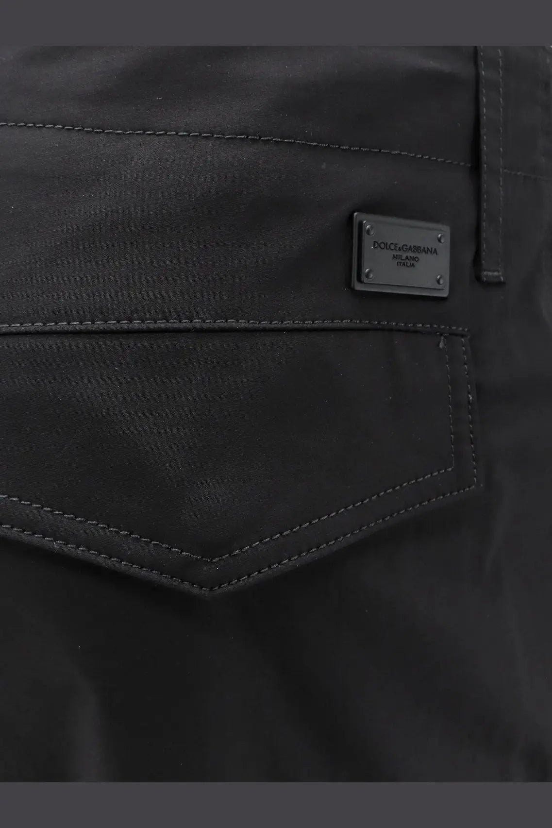 Black dolce and gabbana milano italy label on dark fabric pocket with contrasting stitching of mens cargo stretch cotton trousers
