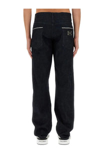 Back side of dolce &amp; gabbana men’s cimosed black denim jeans with white stitching and metallic brand patch on pocket