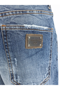 Back side of blue cotton denim dolce and gabbana men’s jeans with distressed frayed pocket and brown leather patch