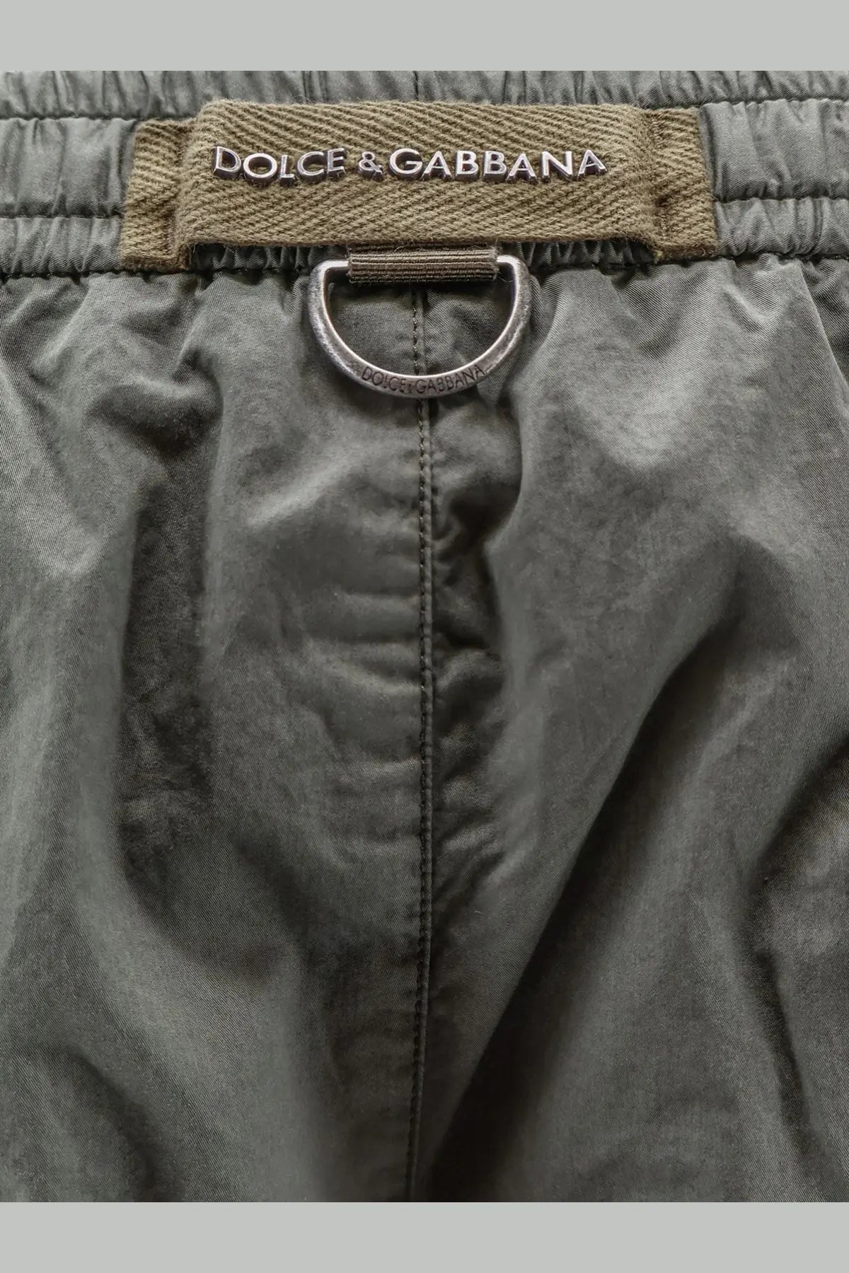 Dolce &amp; Gabbana men’s cotton olive green drawstring shorts with metallic ring and brand label in front view