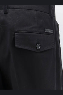 Dolce &amp; Gabbana men’s black cotton trousers showing textured fabric and buttoned flap pocket with subtle brand label