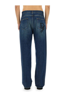 Dark blue denim dolce &amp; gabbana men’s oversize jeans back side featuring a prominent black embroidered logo on pocket