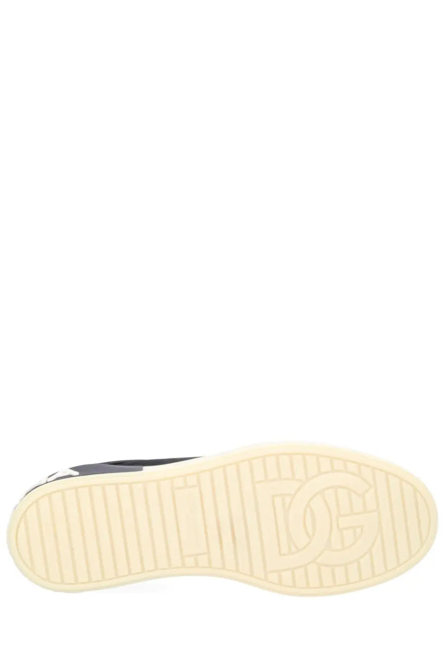 Cream-colored rubber sole with embossed dg logo and textured grip lines on dolce &amp; gabbana men’s black sneaker