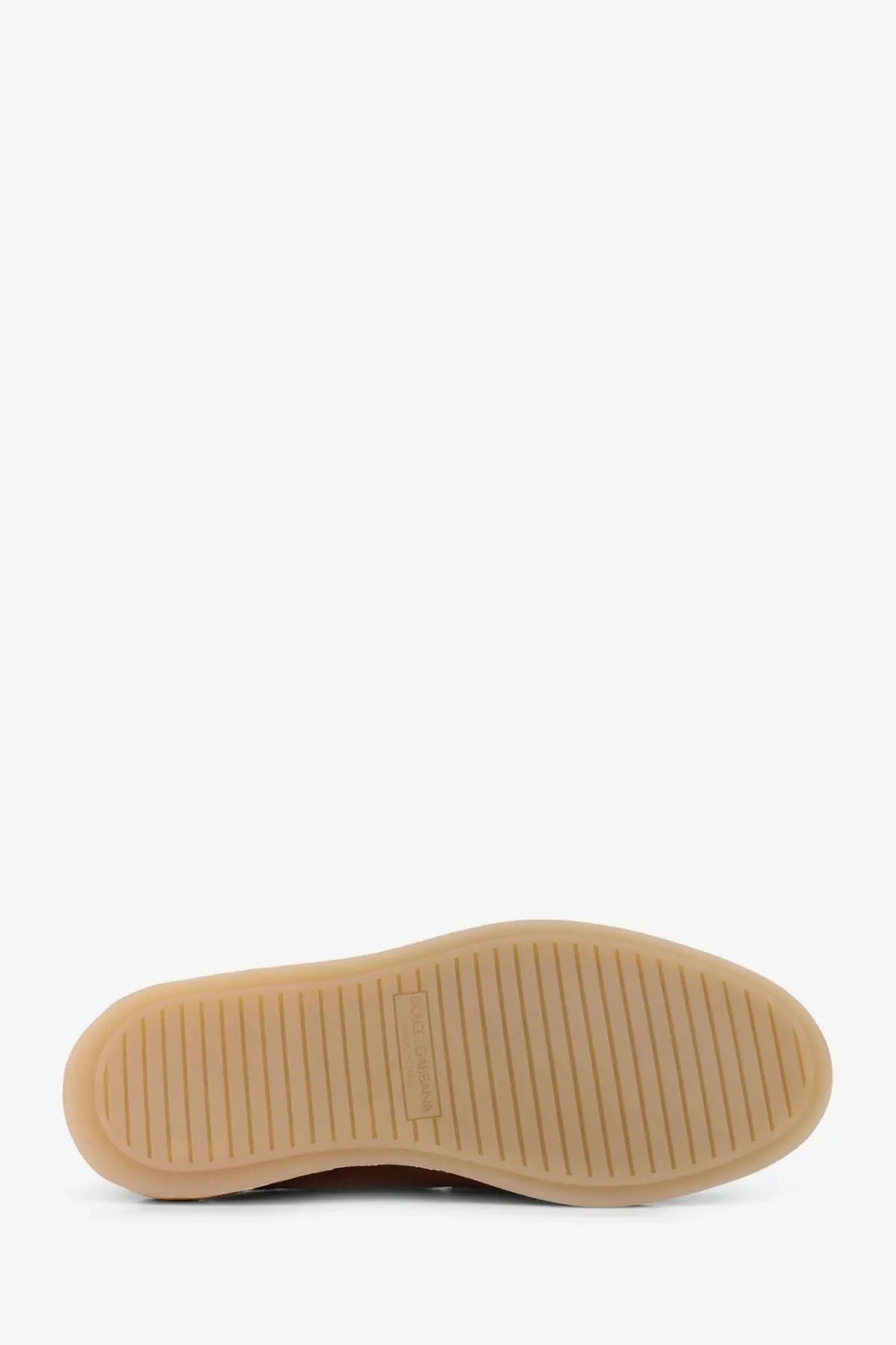 Tan rubber sole of dolce &amp; gabbana men’s beige suede slipper loafers with textured ribbed pattern and brand label near heel