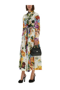 A woman wearing a dolce &amp; gabbana long-sleeved belted floral print poplin dress with vibrant multicolor blossoms