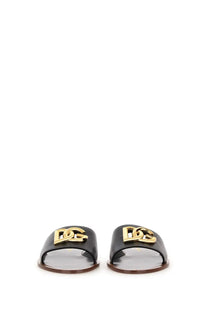 Dolce &amp; Gabbana women’s black leather slide sandals with a gold-tone DG logo plaque on the upper strap