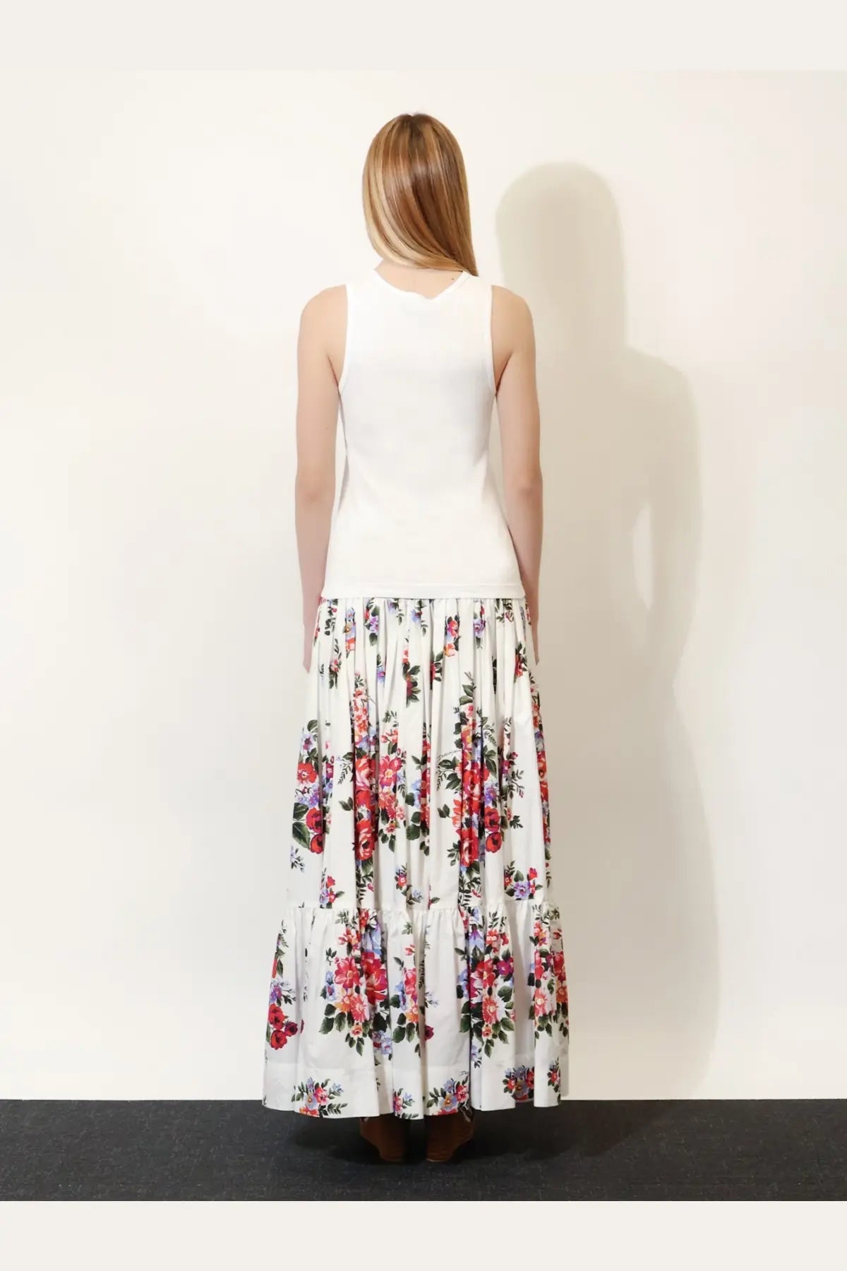 A woman wears a dolce &amp; gabbana women’s white ribbed cotton sleeveless top paired with a floral maxi skirt