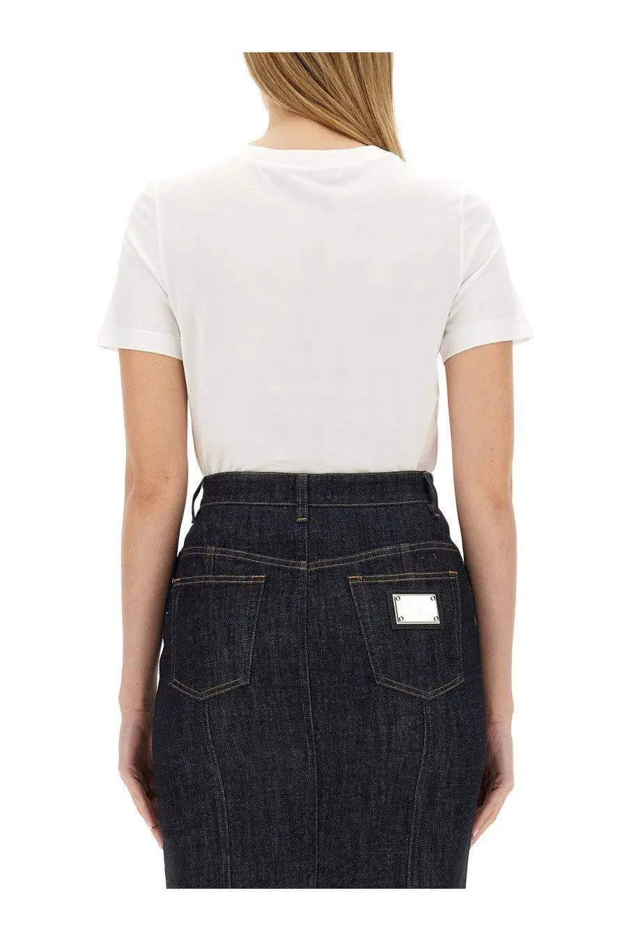 Dark blue denim skirt with silver rectangular patch on back pocket shown from the back complementing dolce &amp; gabbana women’s shirt white