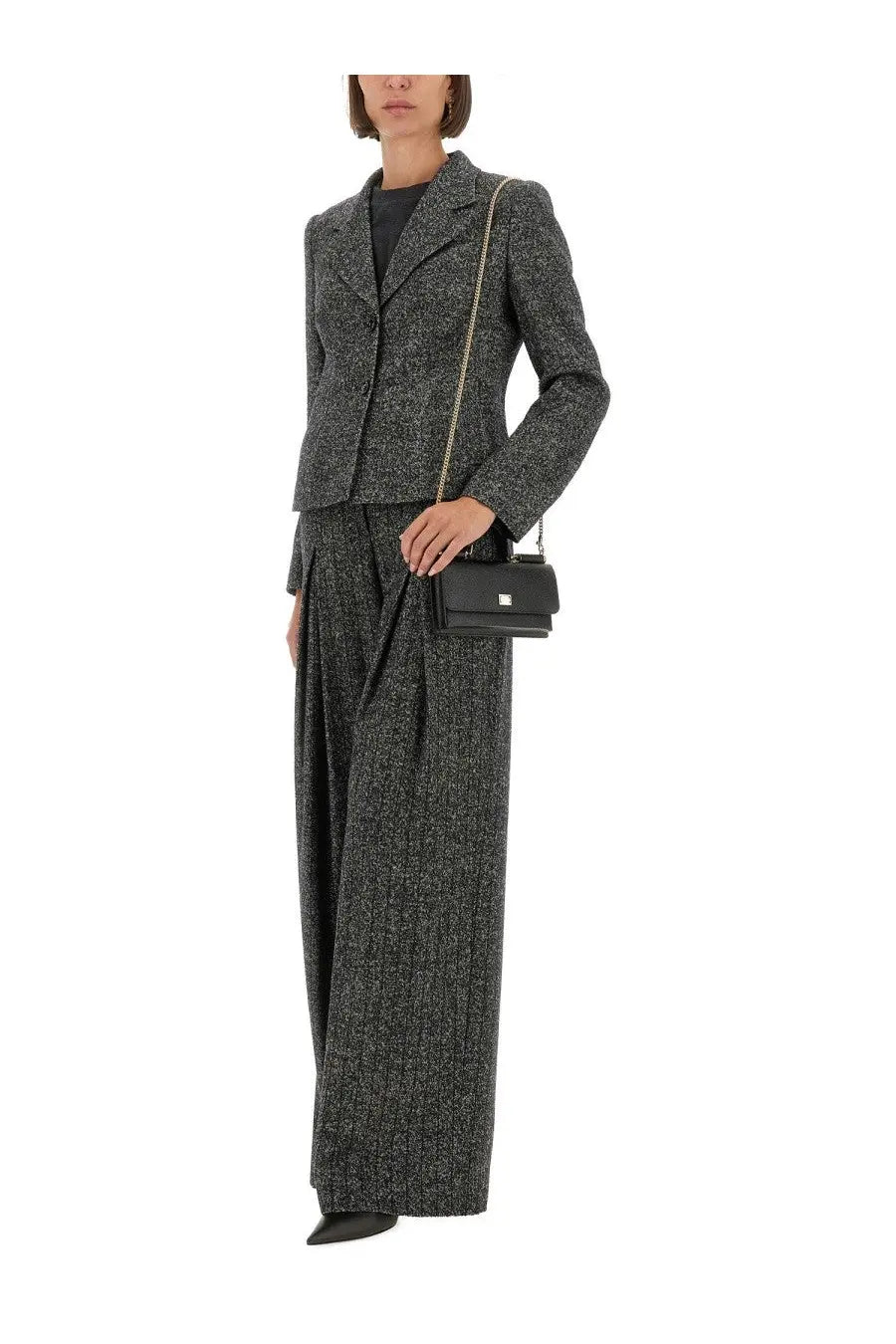 Black leather crossbody bag with gold-tone chain strap and minimalist clasp paired with dolce &amp; gabbana wool blend jacket