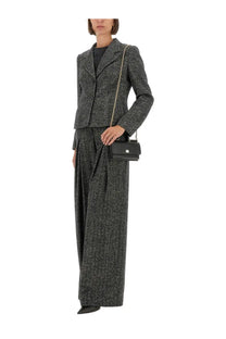 Black leather crossbody bag with gold-tone chain strap and minimalist clasp paired with dolce &amp; gabbana wool blend jacket