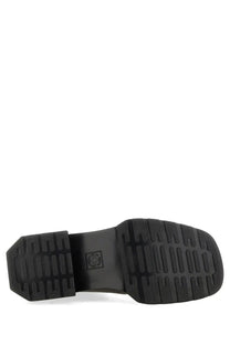 Black rubber sole of dr martens women’s maybole chelsea boot with textured ribbed pattern and embossed logo near heel