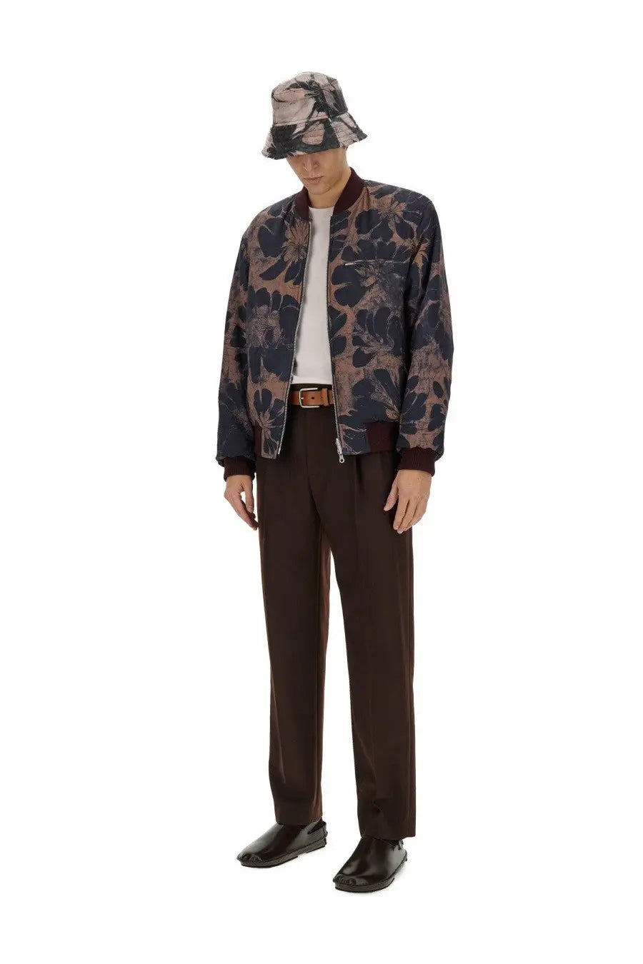 A man wearing a dries van noten men’s reversible jacket blue with a dark navy floral pattern paired with matching trousers